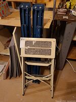 Blue folding work-platform legs and cream two-step stool folded together