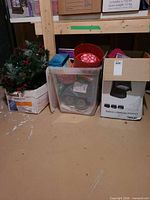 Overall lot showing tote with boxes and tins, garland box, additional cardboard box