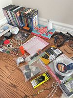 Overview of DVDs, VHS sets, CDs and accessories spread on floor