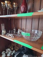 Shelf view showing bowl, tray, candle holder, angel figurines and utensils