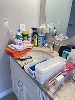 Overall lot on bathroom vanity showing cleaning sprays, microfiber cloths, wipes, organizers and accessories