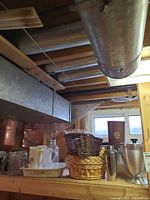 Wide shot of shelf holding wicker baskets, glass jars, white tray and other items