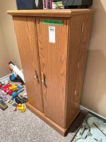 Full front view of closed oak veneer cabinet showing doors and hardware