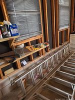 Both stacked aluminum extension ladders along garage wall