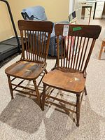 Pair of wooden Windsor spindle back chairs front view showing overall design and wear