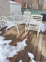 Patio table and chairs on deck, snow visible