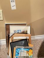 Stack of assorted photo frames leaning against wall