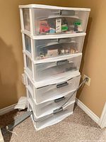 Full view of five-drawer plastic storage unit against wall