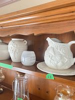 Shelf view showing embossed pitcher on tray, grape-relief vase
