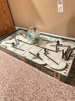 Full view of tabletop hockey game with jar containing extra players