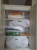 Cabinet with all items: duvet, blanket, sheet set, vacuum bags