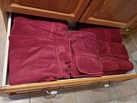Multiple burgundy towels folded in drawer