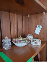 Shelf view showing porcelain pieces and crystal jar together