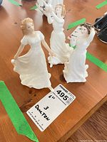 Three Royal Doulton white dress figurines on table