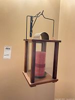 Lantern hanging from wall bracket with candle visible