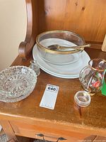 Group of glass and ceramic serving pieces on wooden surface