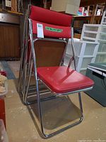 Front view of stacked red folding chairs