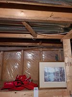 Framed print leaning against wall with red Canada caps visible