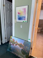 Wall view showing both Marg Luker pieces: framed abstract floral and large canvas landscape