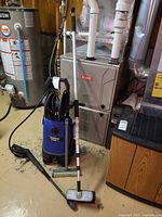 Simoniz pressure washer with hose reel and accessories on floor