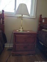 Nightstand between beds with lamp on top