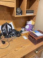 Headphones on charging base with power adapter and RCA cable visible on desk