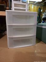 Front view showing three translucent drawers in white frame