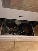 Drawer showing nested frying pans and saucepan