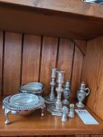 Group shot of all eight silver-tone pieces on shelf