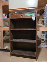Front view showing three shelves and drawer