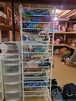 Full front view of tall white wire shelving unit with ten baskets filled with linens