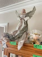 Tallest 17 in angel topper and 5 in mini angel shown on shelf