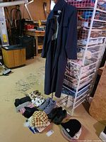 Full lot overview showing coat on hanger, footwear pairs, hats, scarves and gloves