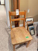 Front view of wooden chair showing seat wear and back slats