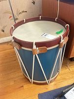 Full view of blue rope-tension field drum showing top head, shell, hoops, ropes, leather ears