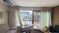 Curtains hanging across patio door and adjacent window on ceiling track