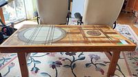 Full view of coffee table showing wood frame and patterned ceramic tile top
