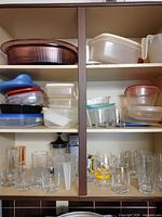 Shelf with assorted plastic containers and glassware