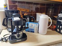 Group shot of espresso maker, drip coffee maker, blender jar, kettle, Brita filters