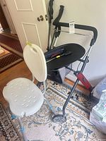 Rollator, tray, basket, trekking poles and bath chair grouped together