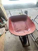 Top view of red tub wheelbarrow showing interior wear and holes