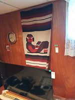 Full view of tapestry hanging on wall showing design and size reference