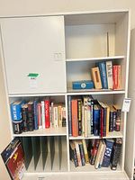 Front view of white laminate cabinet with upper sliding doors and lower open compartments