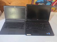 Both Dell laptops side by side open to illustrate models and sizes