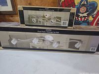 Both boxed Canarm track lights showing product images and labeling