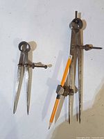 Both divider compasses side by side for size comparison