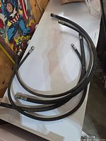 Four coiled hydraulic hoses on table