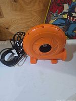 Front view of orange centrifugal blower with power cord