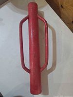 Top view of red steel fence post driver showing handles