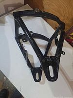 Side view of black Harley-Davidson swingarm showing tubular frame and mounting points